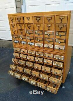 Vintage Oak 60 Drawer Library Card Catalog cabinet with some full trays